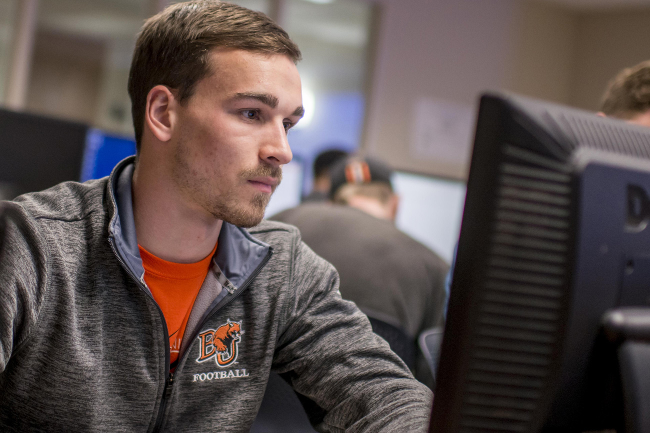 Male student sitting and looking at a computer screen