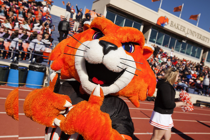 Baker University mascot, Wowzer, giving two thumbs up at a football game
