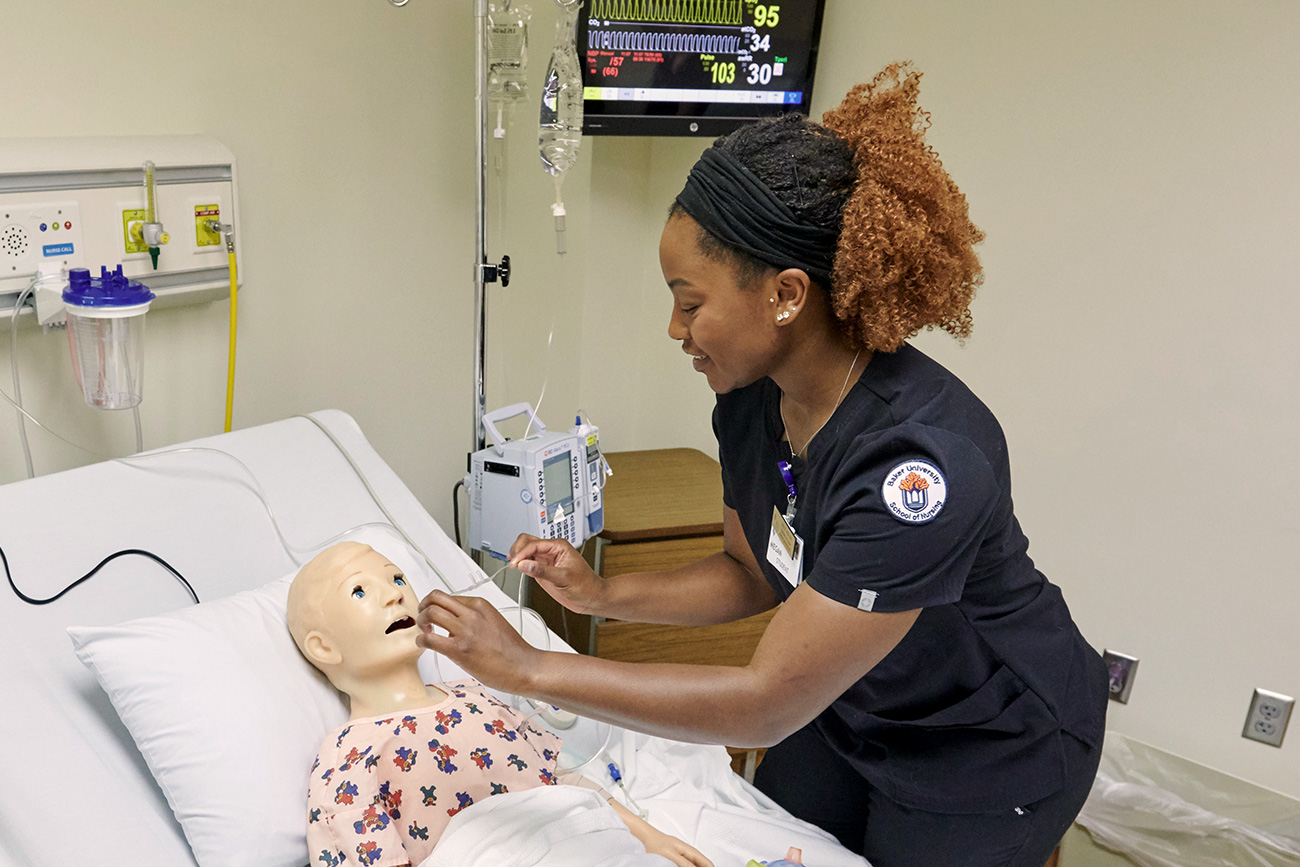 Female nursing student practicing on a child simulation mannequin