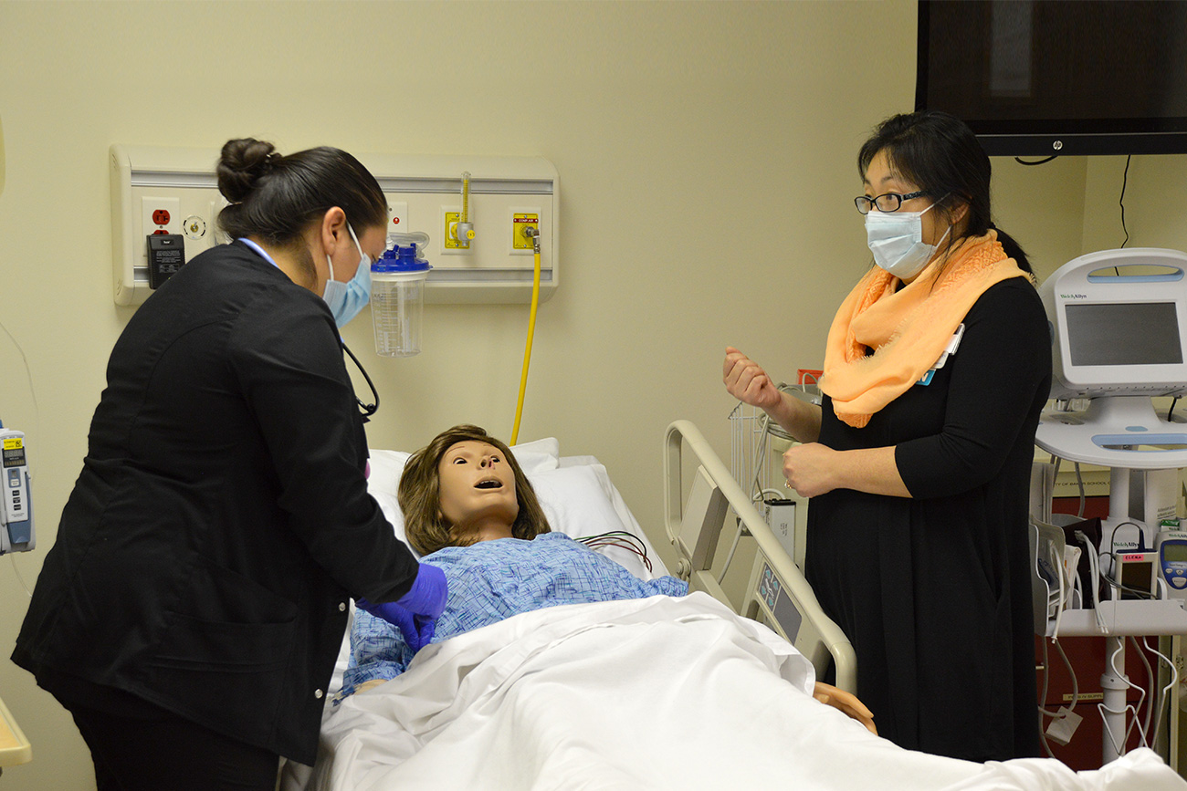 Female nursing student practicing on simulation mannequin