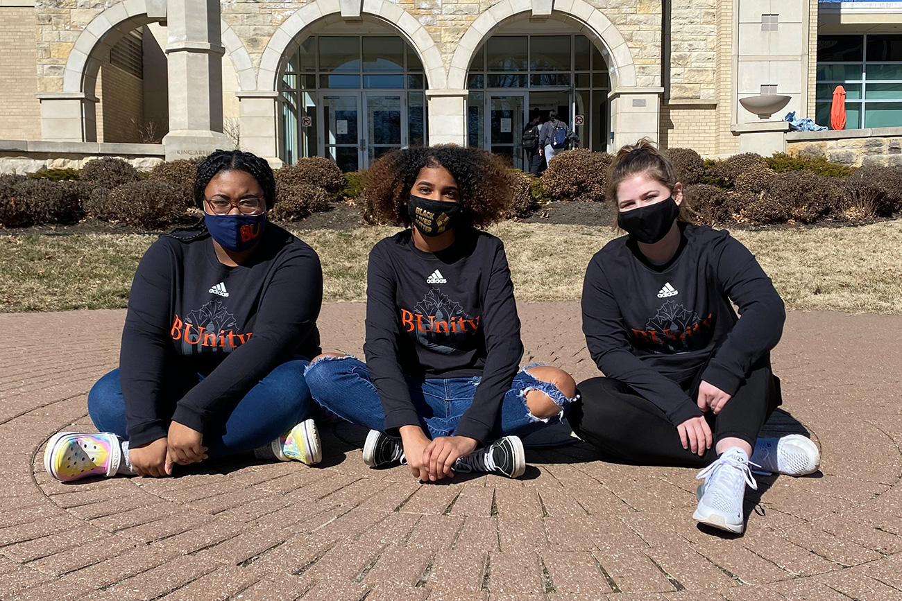 Three students on Hartley Plaza.