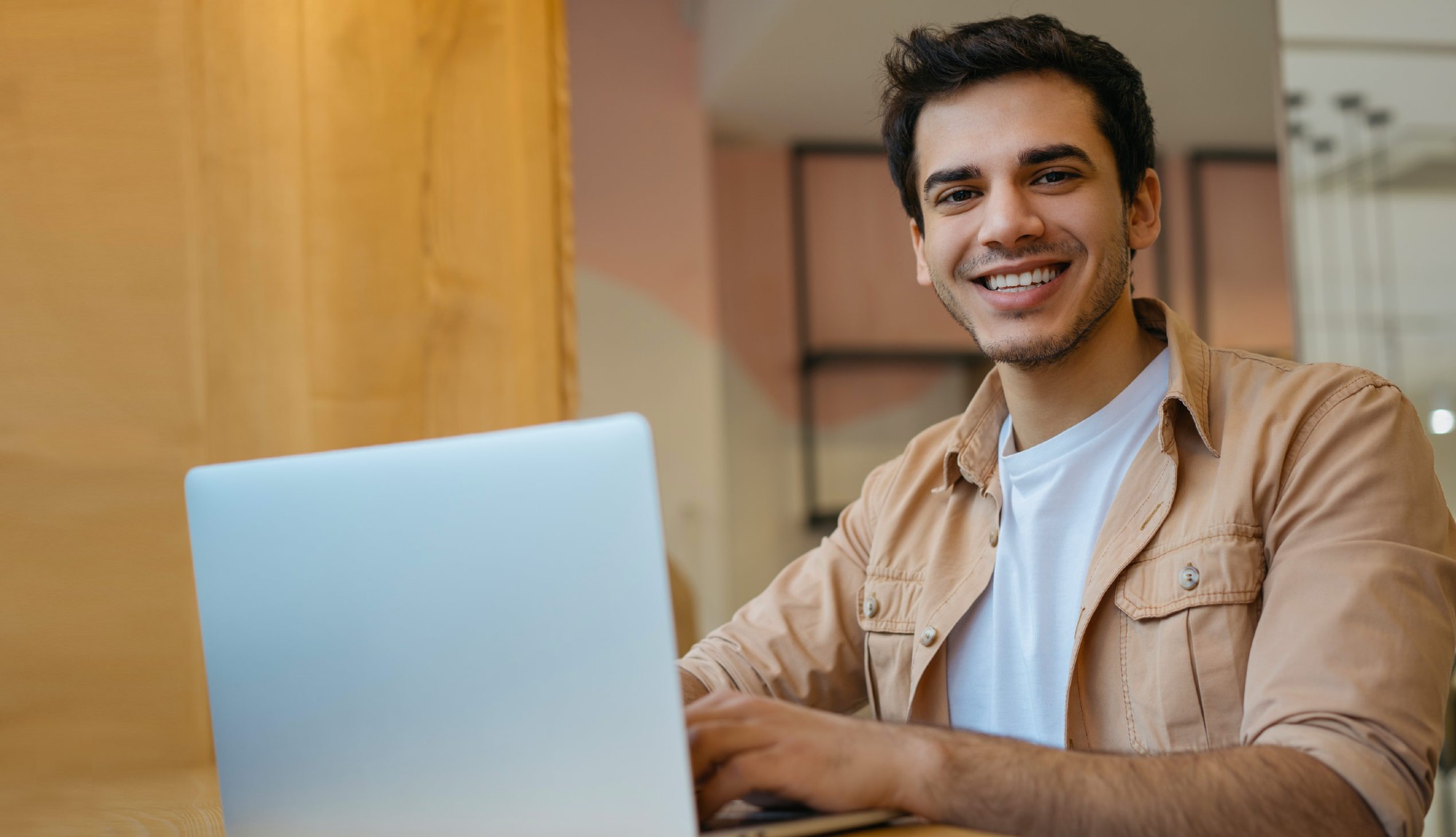 student smiling while while working on laptop
