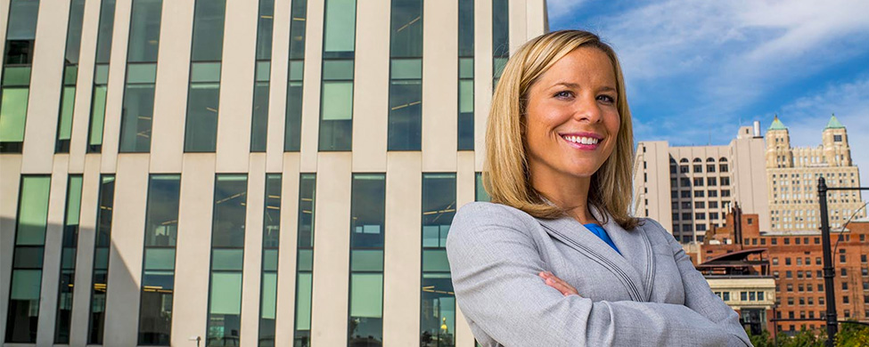 Business woman with Kansas City skyline behind her.