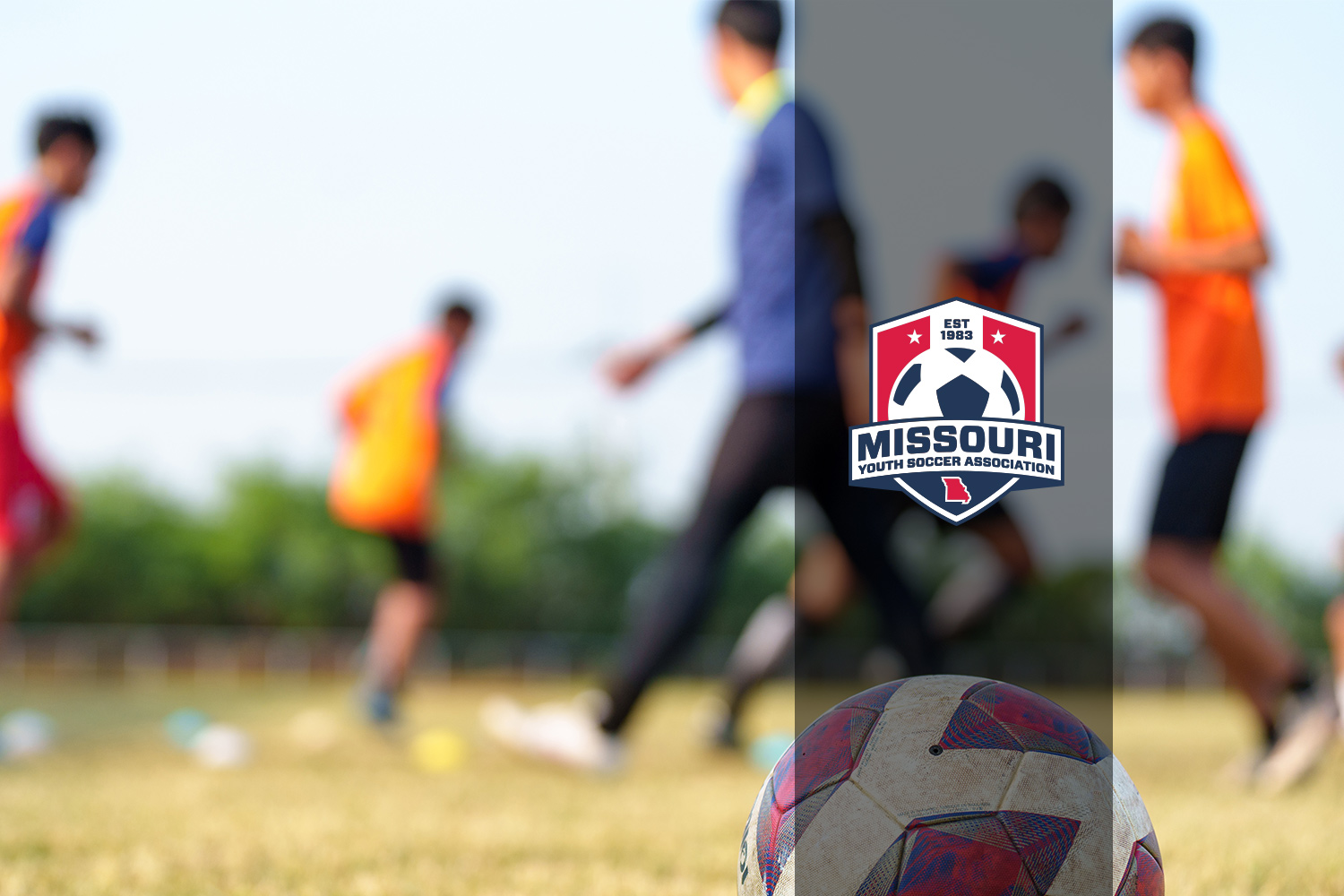 kids playing soccer as coach walks by with Missouri Youth Soccer logo