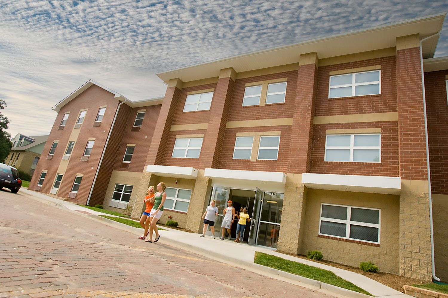 Students crossing red brick street from New Living Center to the student union.